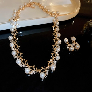 Detail of luxury pearl and diamond necklace set with elegant vine leaf design in gold