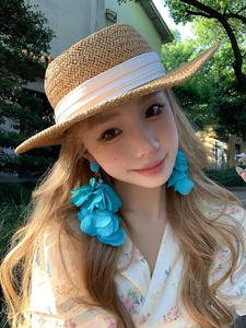 Boucles d'oreilles fleurs bleues et chapeau de paille pour un look de vacances d'été