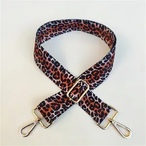 Adjustable leopard print bag strap with golden metal hooks on white background