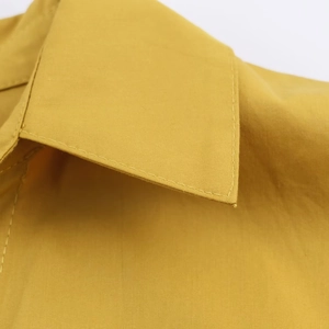 Gros plan détaillé du col d'une chemise en popeline jaune avec couture à double piqûre