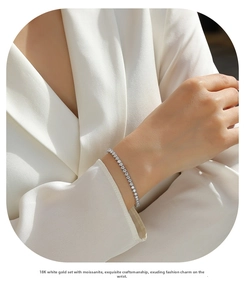 Detail view of a 18K white gold moissanite tennis bracelet on a silk sleeve
