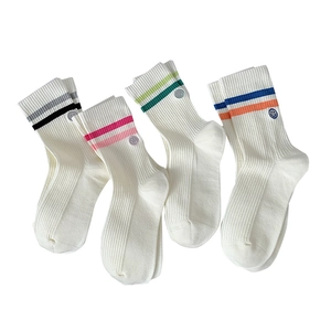 Set of four white cotton crew socks with colorful stripes and smiley face embroidery