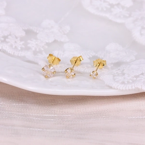 Macro shot of three golden S925 sterling silver stud earrings with clear round zircons