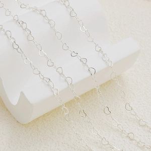 Macro shot of 14K silver heart-shaped chain links for jewelry making accessories