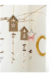 Close-up of Nordic wood Christmas ornaments with bells and beads on a branch