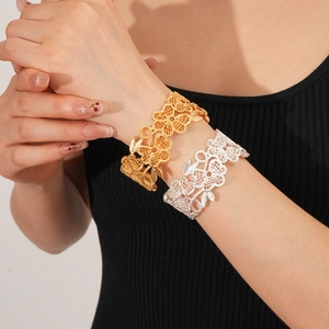 Detailansicht der hohlgeformten Armreifen mit Blumenmuster in Gold und Silber