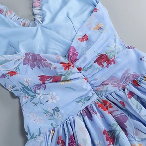 Detail von Rüschen am Ausschnitt und Blumenmuster auf dem hellblauen Sommerkleid