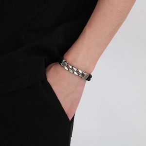 Detail of men's vintage leather bracelet with magnetic clasp and steel Cuban link pattern