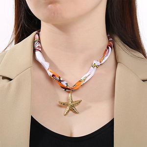 Pendentif étoile de mer élégant avec collier foulard en soie orange et blanc sur modèle