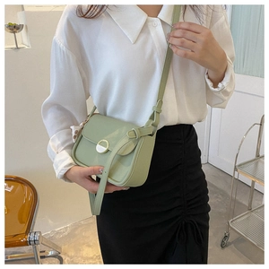 Fashionable light green chain shoulder bag shown on model in a minimalist setting