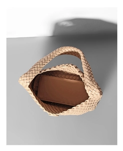 Vista dall'alto di una borsa tote intrecciata beige con pochette interna e trama liscia