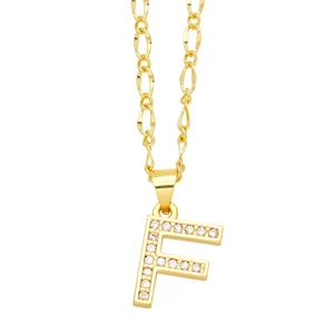 Detailed view of golden letter F pendant with micro-paved zircons on a Figaro chain