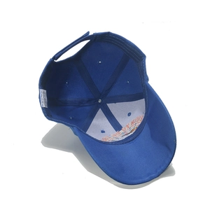 Detail of the blue baseball cap interior showing 100% acrylic tag and adjustable strap