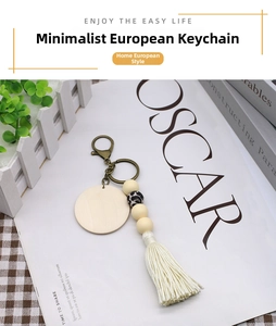 Detail of boho keychain with wooden disc, leopard print bead, and white cotton tassel