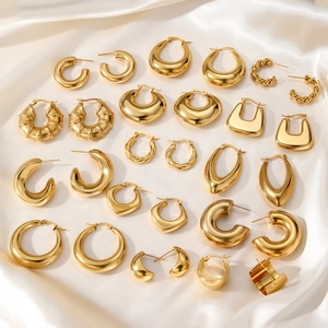 Collection of minimalist gold-plated geometric earrings on white satin fabric background