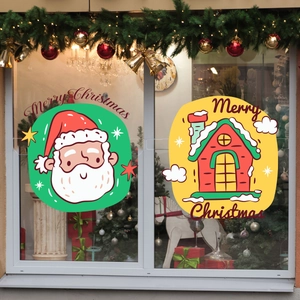 Detail of Santa Claus and cottage Christmas window decals on glass with festive decor