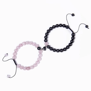 Detailed macro view of heart magnetic clasp connecting black and pink beaded bracelets