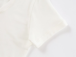 Close-up of sleeve stitching and soft cotton knit texture on white U-neck t-shirt