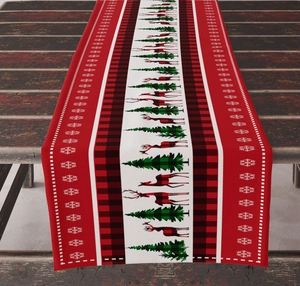 Close-up of linen Christmas table runner with reindeer and snowflake motifs on wood