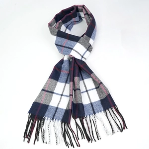 Detail shot of the soft woven texture and fringe of a blue and red plaid scarf