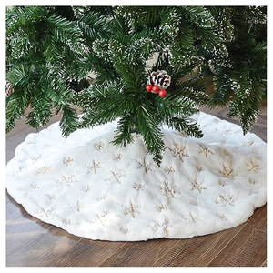 Detail of white faux fur Christmas tree skirt with golden snowflake embroidery on floor