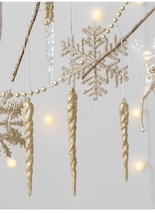 Detail of hanging gold snowflake and icicle ornaments with glitter finish for Christmas