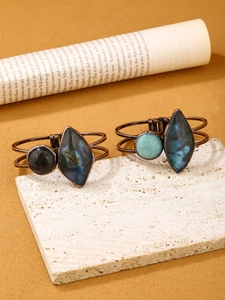 Detailed view of vintage bronze bracelet with natural labradorite on a textured display