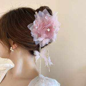 Dettaglio molletta per capelli con fiore di pizzo rosa, cristalli e nappe a farfalla