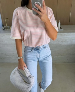 Selfie miroir avec un t-shirt à rayures roses et blanches et un jean bleu clair déchiré
