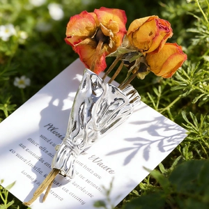 Artistic silver bouquet brooch featuring dried yellow roses on a green grass setting