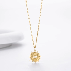 Detail view of gold sunburst evil eye necklace with a clear cubic zirconia stone