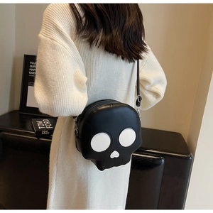 Detailed back view of a black gothic skull-shaped crossbody bag on a white sweater