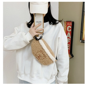 Detail of plush teddy bear embroidered waist bag with fuzzy material and black chain