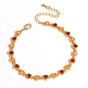 Detail of gold evil eye bracelet with orange enamel charms and dark red zircon accents
