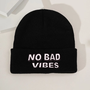 Close-up of NO BAD VIBES white embroidery on a black knitted beanie with high-quality texture