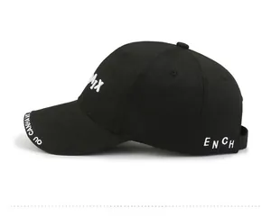 Detail of white 3D embroidery on a black cotton baseball cap with premium stitching