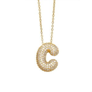 Close-up of golden balloon letter C pendant paved with shimmering white cubic zirconia