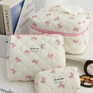 Three-piece quilted cotton cosmetic bag set with pink bows and zipper closure