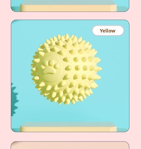 Detailed view of yellow spiked TPR dog toy ball with dental cleaning textured surface