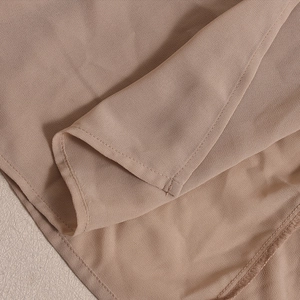 Detailaufnahme von aprikosenfarbenem Chiffonstoff mit feinen Nähten und Doppelnaht-Finish