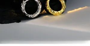 Detail of irregular lava texture on gold and silver hammered metal huggie hoop earrings