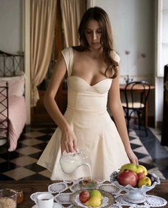 Close-up of white off-shoulder mini dress with corset-style bodice and lace-up back detail