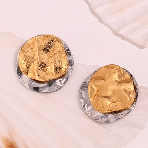 Close-up of dual-tone wavy round stud earrings with metallic texture on shell background