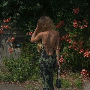 Detail of the backless floral maxi dress with cross straps and deep green botanical print