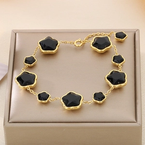 Bracelet en acier titane doré avec trèfles noirs à cinq feuilles sur boîte à bijoux