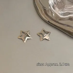 Detail of silver star hair clips with hollow design on a minimalist metal tray