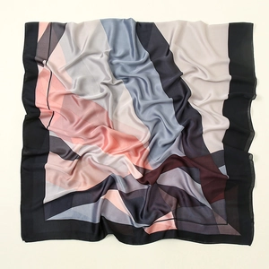 Detail of soft satin scarf with geometric pink and grey patterns showing fabric texture