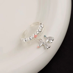 Macro shot of silver balloon dog charm ring with pink accents and sparkling zircons