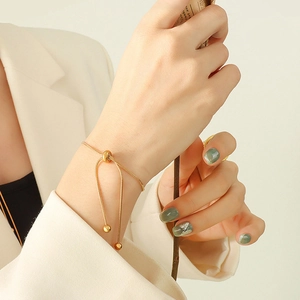 Detail of adjustable gold-plated snake bone chain bracelet worn on a model's wrist