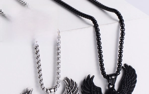 Close-up of eagle wing pendants in silver and black with detailed feather texture